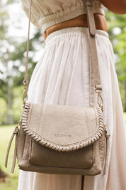 A model wearing the Shania Crossbody Bag in colour Stone, from the front, showing the whole outfit
