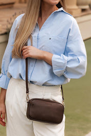 A model wearing the Bianca Crossbody Bag in colour Chocolate, from the front, showing the whole outfit