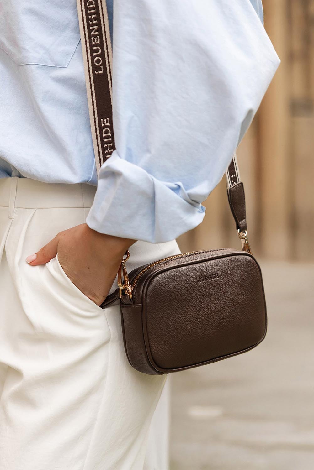 A model wearing the Bianca Crossbody Bag in colour Chocolate, from the front, showing the whole outfit