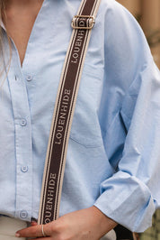 A model wearing the Bianca Crossbody Bag in colour Chocolate, from the front, showing the whole outfit