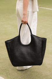 A model wearing the Alexandra Tote Bag in colour Black (Black), from the front, showing the whole outfit
