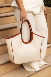 A model wearing the Alexandra Tote Bag in colour Natcanvas, from the front, showing the whole outfit