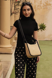 A model wearing the Clare Woven Handbag in colour Blackraff, from the front, showing the whole outfit