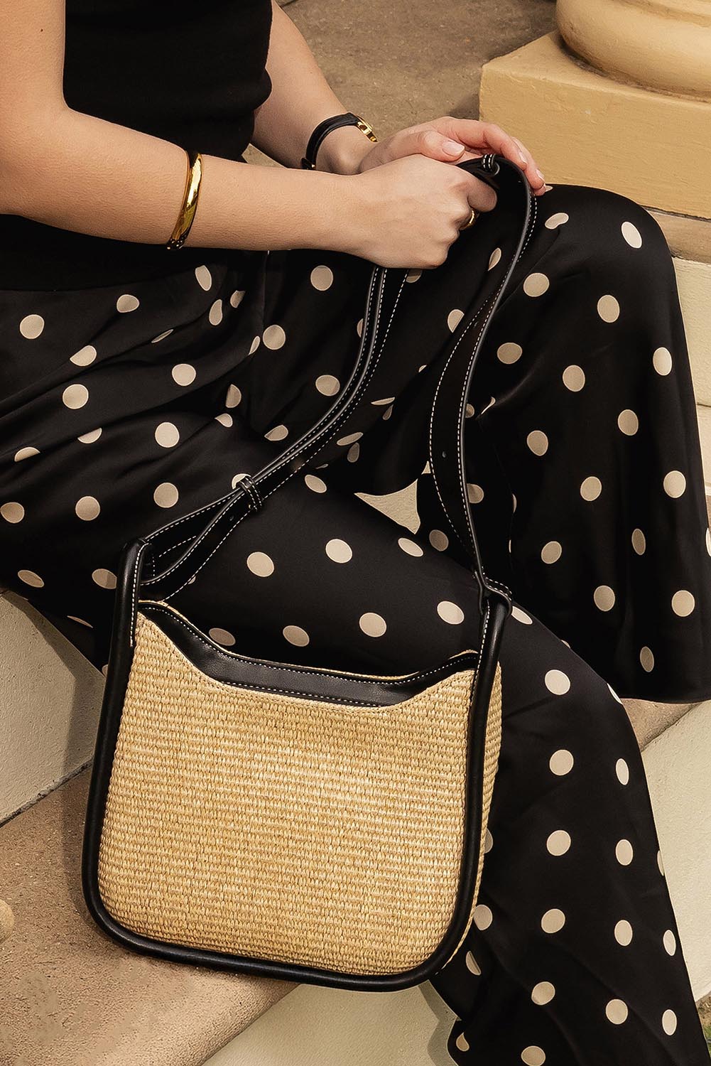 A model wearing the Clare Woven Handbag in colour Blackraff, from the front, showing the whole outfit