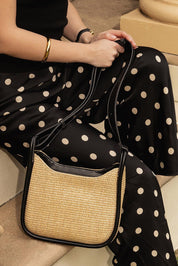 A model wearing the Clare Woven Handbag in colour Blackraff, from the front, showing the whole outfit