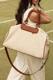 A model wearing the Taylor Travel Bag in colour Canvastan, from the front, showing the whole outfit