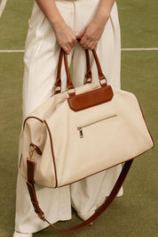 A model wearing the Taylor Travel Bag in colour Canvastan, from the front, showing the whole outfit