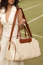 A model wearing the Taylor Travel Bag in colour Canvastan, from the front, showing the whole outfit