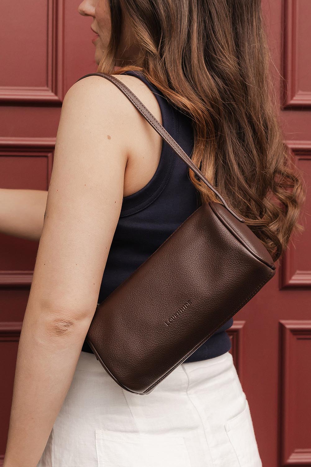 A model wearing the Serena Handbag in colour Chocolate, from the front, showing the whole outfit