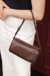 A model wearing the Serena Handbag in colour Chocolate, from the front, showing the whole outfit