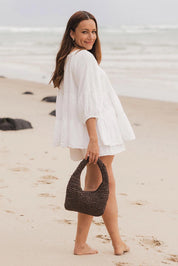 A model wearing the Nellie Woven Handbag in colour Chocolate, from the front, showing the whole outfit