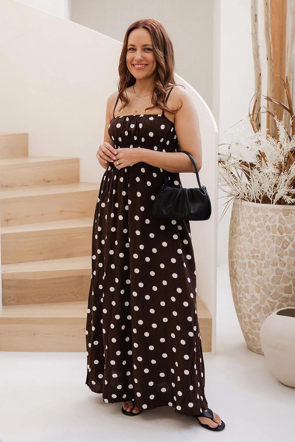 A model wearing the Uma Day Night Crossbody Bag in colour Black (Black), from the front, showing the whole outfit
