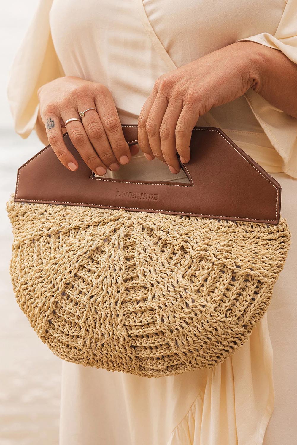 A model wearing the Carmella Bucket Bag in colour Naturtan, from the front, showing the whole outfit