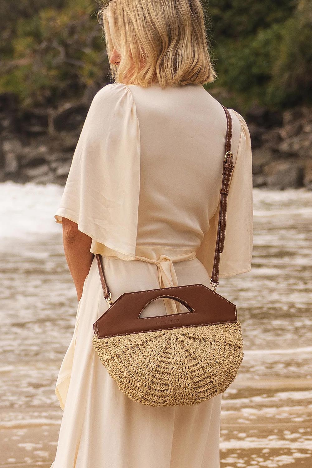 A model wearing the Carmella Bucket Bag in colour Naturtan, from the front, showing the whole outfit