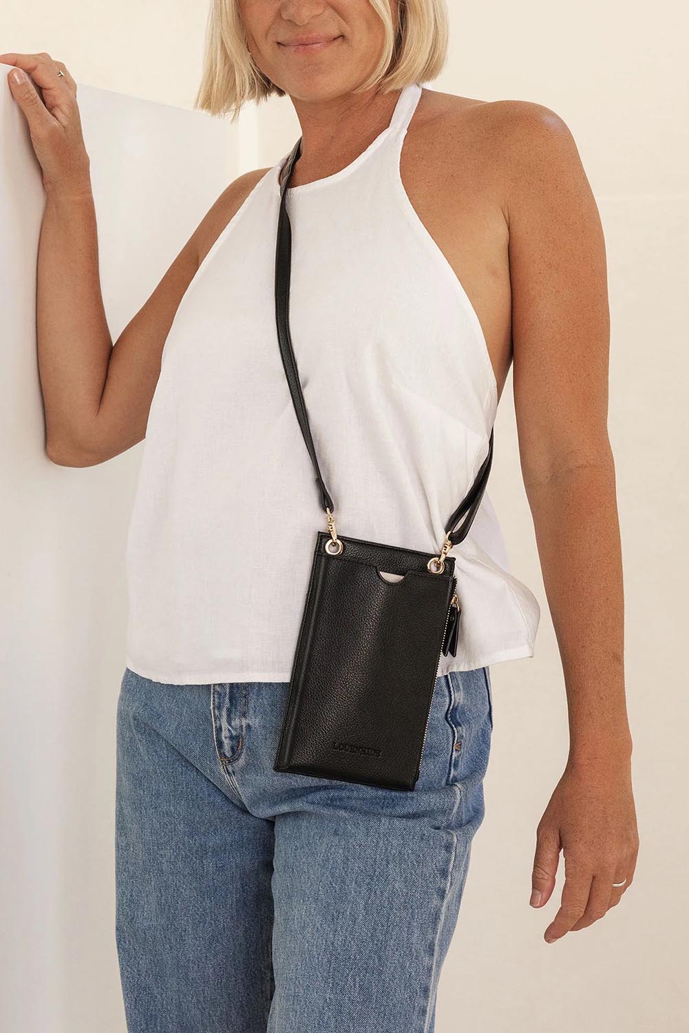 A model wearing the Suki Phone Bag in colour Black (Black), from the front, showing the whole outfit