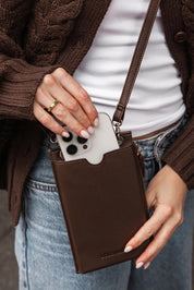 A model wearing the Suki Phone Bag in colour Chocolate, from the front, showing the whole outfit
