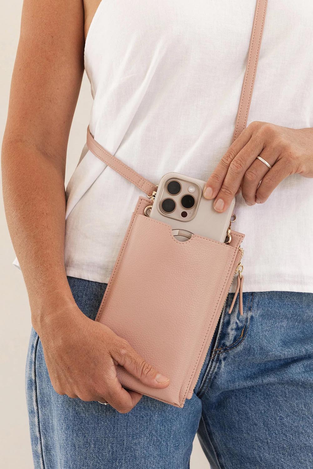 A model wearing the Suki Phone Bag in colour Dustypink (Pink), from the front, showing the whole outfit