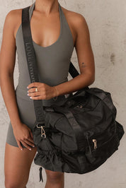 Model Genericm wearing size sample of the Jenn Nylon Travel Bag - Black in colour Black, from an angle