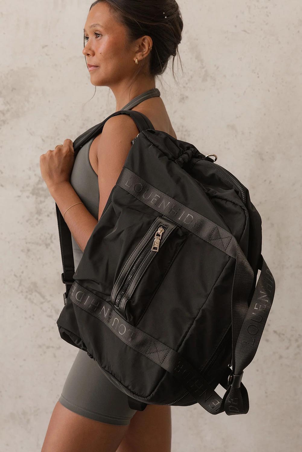 Model Genericm wearing size sample of the Jenn Nylon Travel Bag - Black in colour Black, from an angle