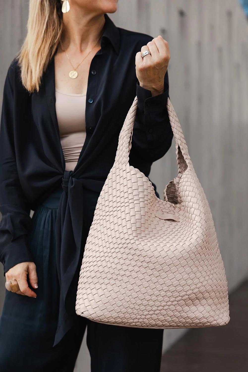 A model wearing the Gabby Woven Shoulder Bag in colour Malt, from the front, showing the whole outfit