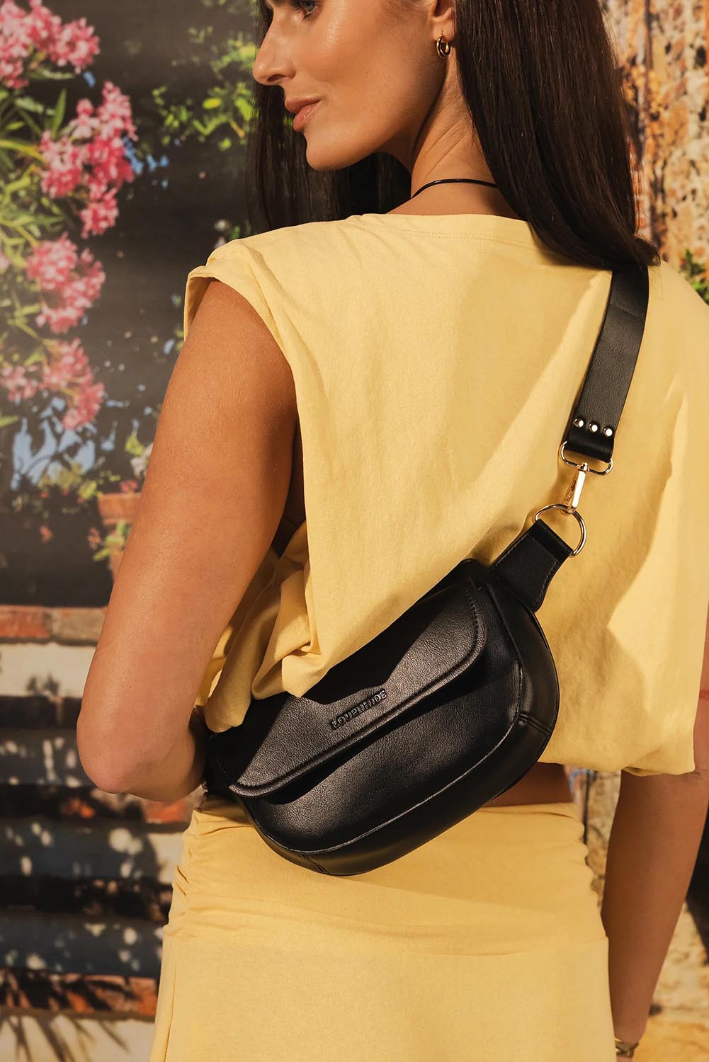Model Genericm wearing size sample of the Lola Belt Bag - Black in colour Black, from an angle