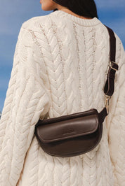 Model Genericm wearing size sample of the Lola Belt Bag - Chocolate in colour Chocolate, from an angle