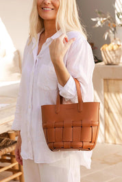 A model wearing the Bettina Bucket Bag in colour Tan, from the front, showing the whole outfit