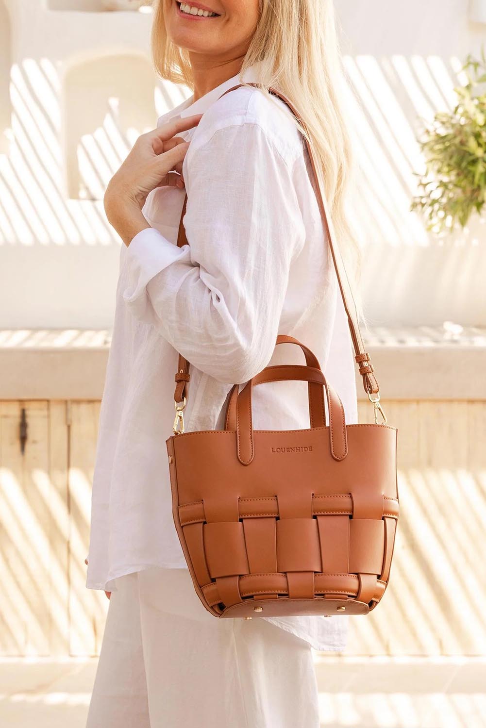 A model wearing the Bettina Bucket Bag in colour Tan, from the front, showing the whole outfit