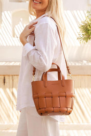 A model wearing the Bettina Bucket Bag in colour Tan, from the front, showing the whole outfit