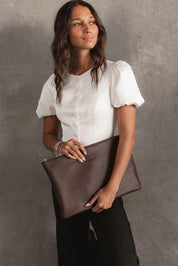 A model wearing the Liv Laptop Sleeve in colour Chocolate, from the front, showing the whole outfit