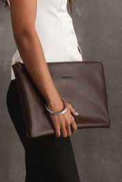 A model wearing the Liv Laptop Sleeve in colour Chocolate, from the front, showing the whole outfit