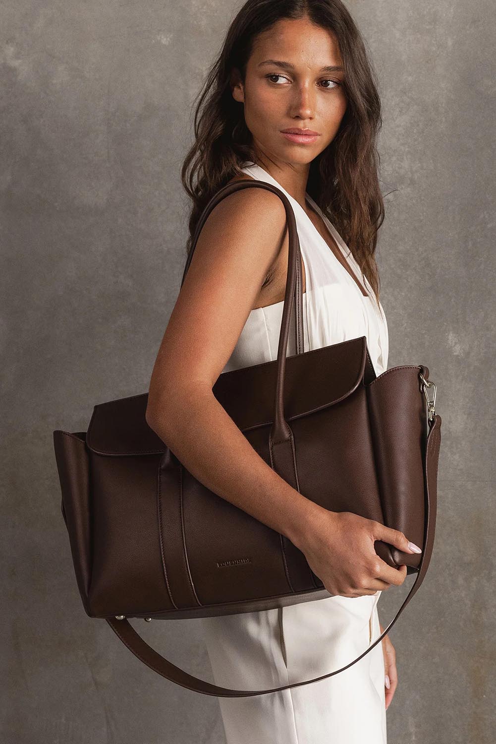 A model wearing the Leighton Tote Bag in colour Chocolate, from the front, showing the whole outfit