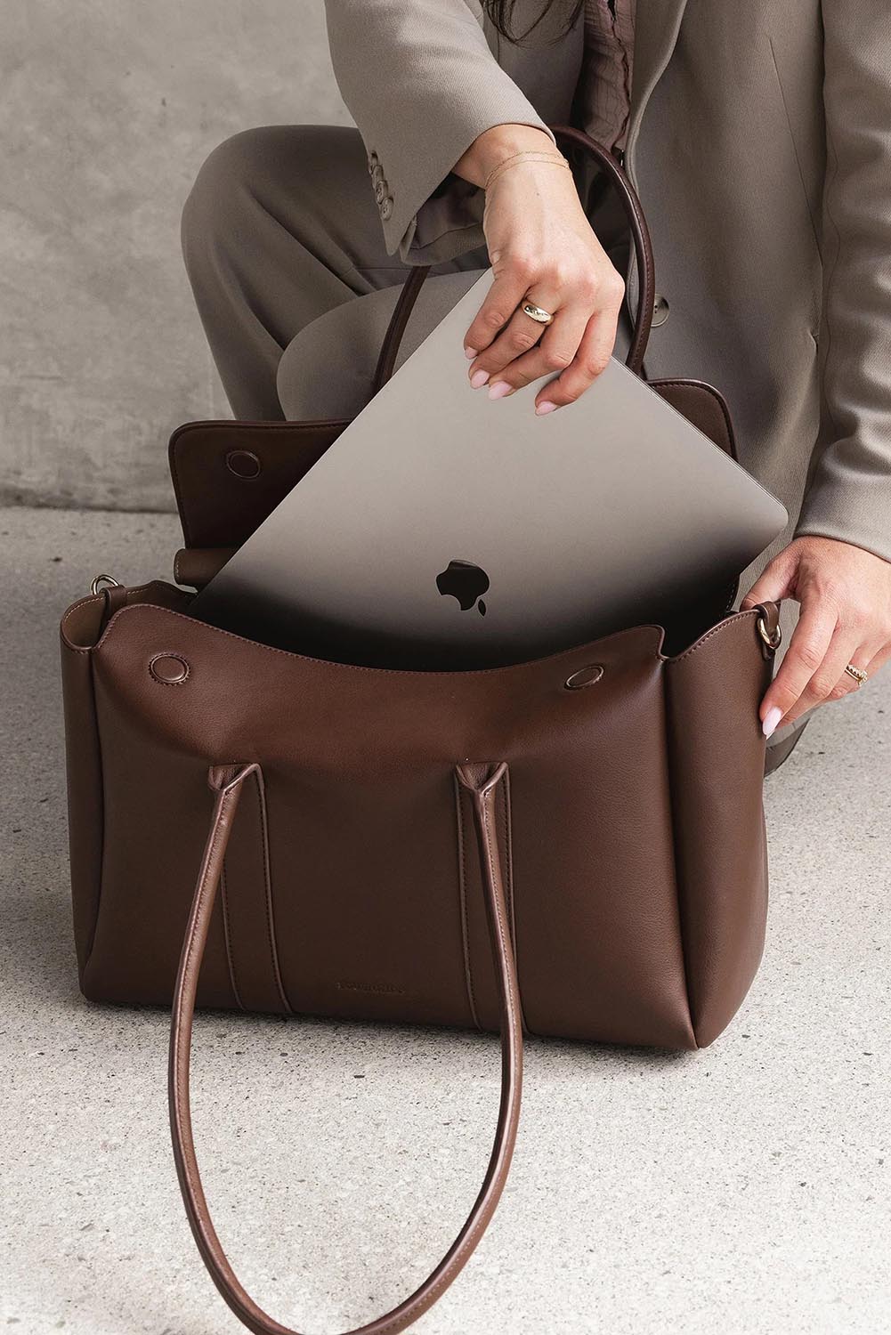 A model wearing the Leighton Tote Bag in colour Chocolate, from the front, showing the whole outfit