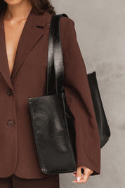 A model wearing the Riley Tote Bag in colour Blackpaten (Black), from the front, showing the whole outfit