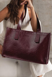 A model wearing the Riley Tote Bag in colour Burgundy (Red), from the front, showing the whole outfit