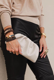 A model wearing the Macy Woven Clutch in colour Malt, from the front, showing the whole outfit