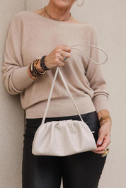 A model wearing the Macy Woven Clutch in colour Malt, from the front, showing the whole outfit