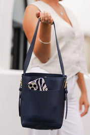 A model wearing the Farrell Shoulder Bag in colour Navy (Blue), from the front, cropped image