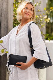 A model wearing the Farrell Shoulder Bag in colour Navy (Blue), from the front, cropped image