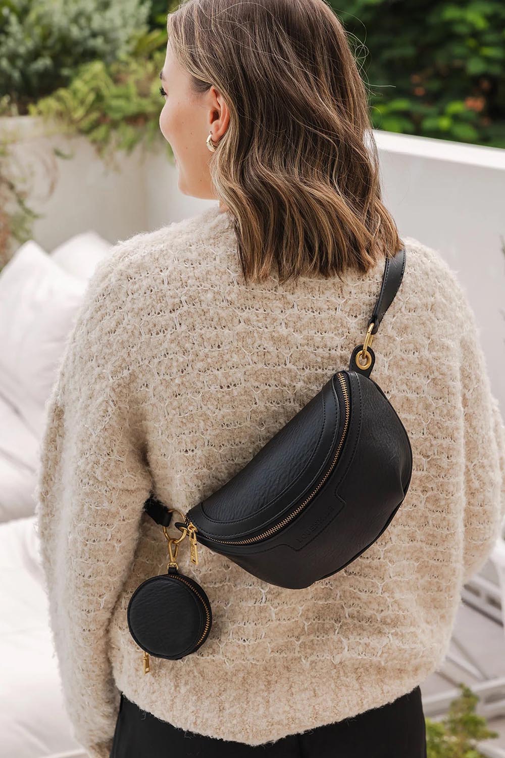 A model wearing the Joey Sling Bag in colour Black (Black), from the front, showing the whole outfit