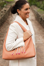 A model wearing the Monaco Shoulder Bag in colour Clay, from the front, showing the whole outfit