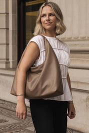 A model wearing the Monaco Shoulder Bag in colour Mocha, from the front, showing the whole outfit