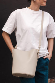 A model wearing the Miranda Bucket Bag in colour Almond, from the front, showing the whole outfit