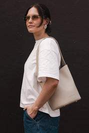 A model wearing the Miranda Bucket Bag in colour Almond, from the front, showing the whole outfit