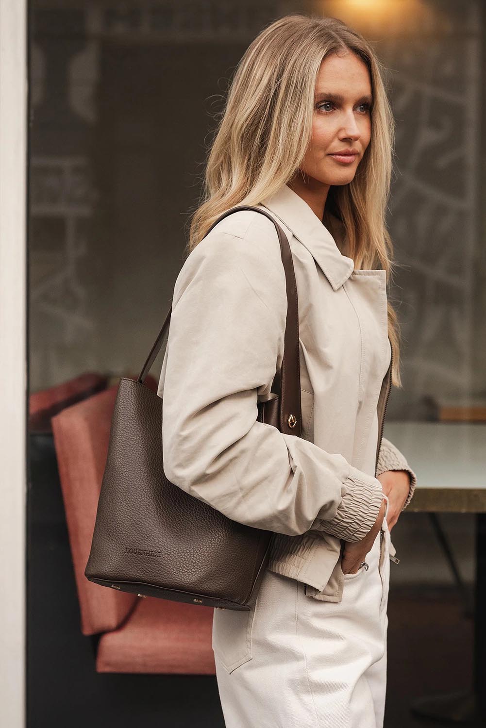 A model wearing the Miranda Bucket Bag in colour Chocolate, from the front, showing the whole outfit