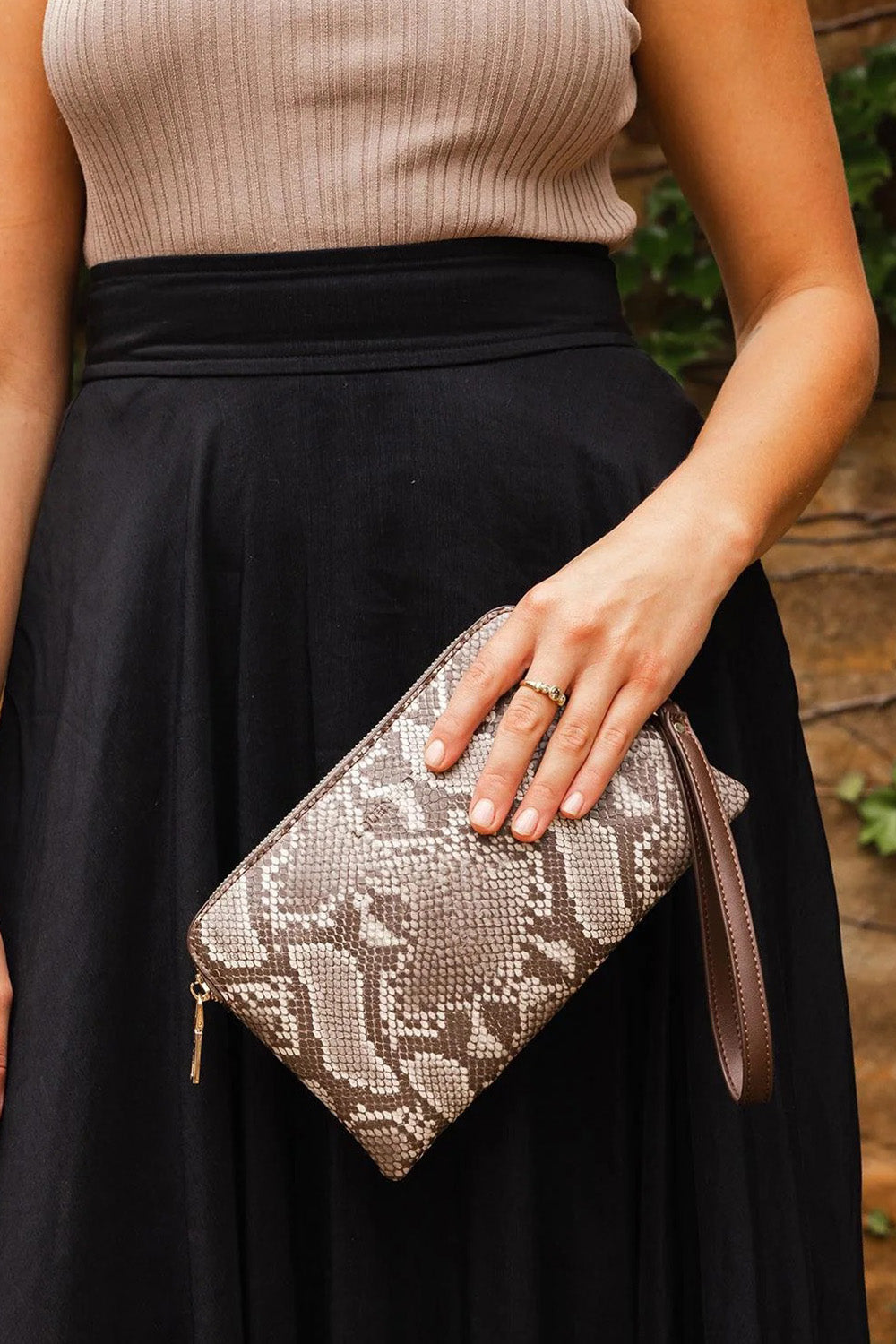 A model wearing the Poppy Clutch in colour Pythoncoff, from the front, showing the whole outfit
