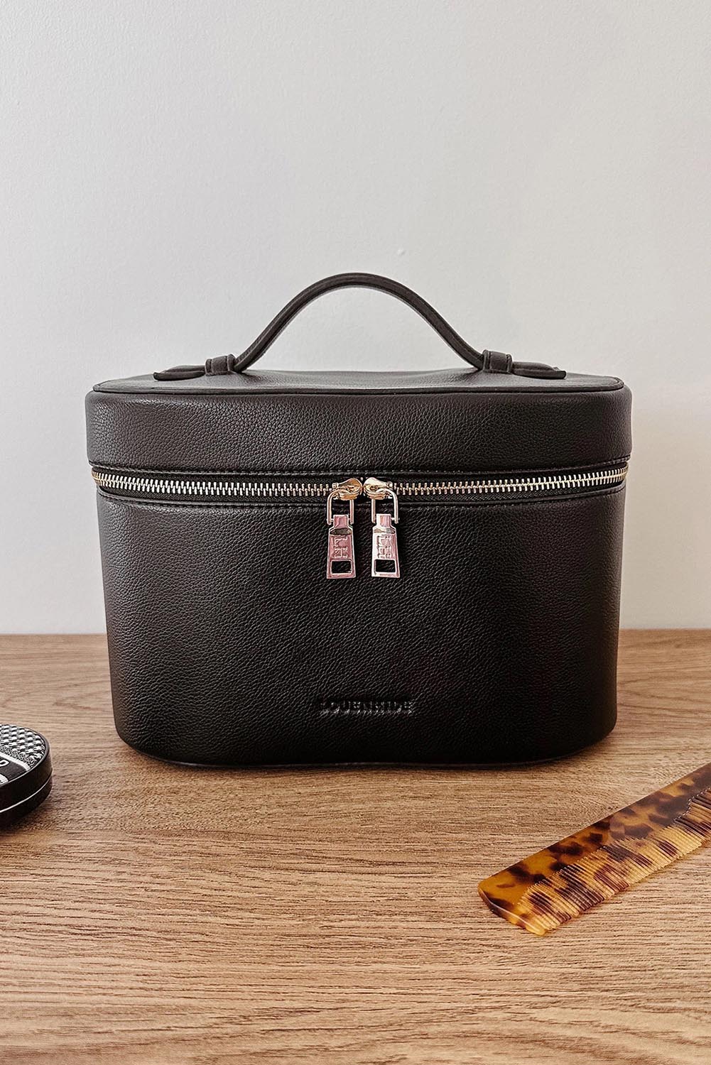 A model wearing the Juliette Toiletries Bag in colour Black (Black), from the front, showing the whole outfit