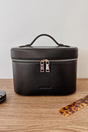A model wearing the Juliette Toiletries Bag in colour Black (Black), from the front, showing the whole outfit