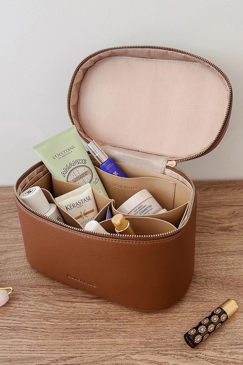A model wearing the Juliette Toiletries Bag in colour Tan, from the front, showing the whole outfit