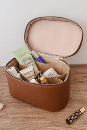 A model wearing the Juliette Toiletries Bag in colour Tan, from the front, showing the whole outfit